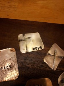 Image of "HOPE" and a cross stamped in metal